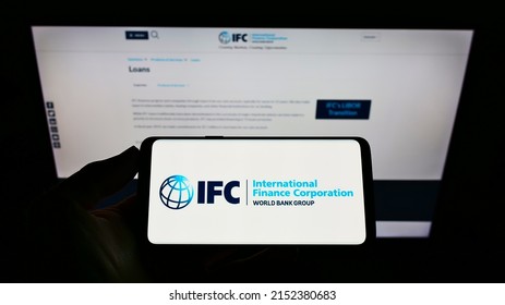 Stuttgart, Germany - 06-13-2021: Person Holding Mobile Phone With Logo Of Institution International Finance Corporation (IFC) On Screen In Front Of Web Page. Focus On Phone Display. Unmodified Photo.