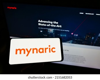 Stuttgart, Germany - 06-18-2021: Person Holding Cellphone With Logo Of German Laser Equipment Manufacturer Mynaric AG On Screen In Front Of Business Webpage. Focus On Phone Display. Unmodified Photo.