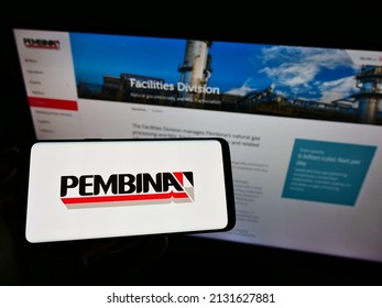 Stuttgart, Germany - 06-19-2021: Person holding cellphone with logo of Canadian transport company Pembina Pipeline Corp. on screen in front of webpage. Focus on phone display. Unmodified photo.