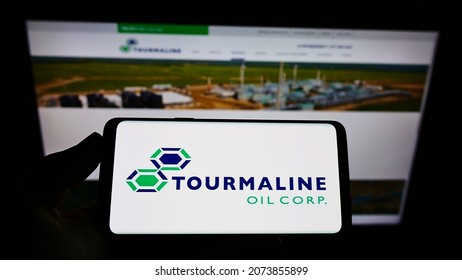 Stuttgart, Germany - 06-20-2021: Person holding mobile phone with logo of Canadian energy company Tourmaline Oil Corp. on screen in front of web page. Focus on phone display. Unmodified photo.