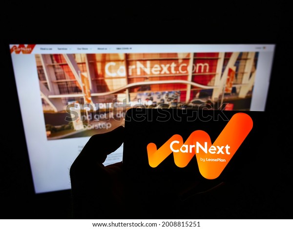 Stuttgart, Germany - 07-11-2021: Person holding\
mobile phone with logo of company LeasePlan Corporation N.V.\
(CarNext.com) on screen in front of web page. Focus on phone\
display. Unmodified\
photo.