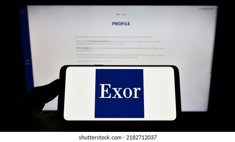 Stuttgart, Germany - 07-15-2022: Person Holding Smartphone With Logo Of Dutch Investment Company Exor N.V. On Screen In Front Of Website. Focus On Phone Display. Unmodified Photo.