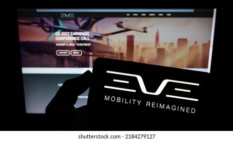 Stuttgart, Germany - 07-24-2022: Person Holding Smartphone With Logo Of Company Eve Holding Inc. (Eve Air Mobility) On Screen In Front Of Website. Focus On Phone Display. Unmodified Photo.