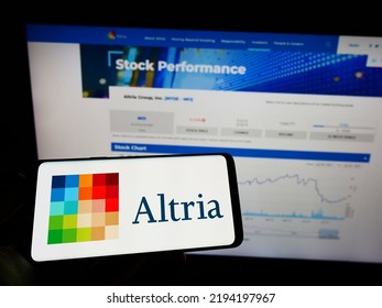 Stuttgart, Germany - 07-30-2022: Person Holding Mobile Phone With Logo Of American Tobacco Company Altria Group Inc. On Screen In Front Of Web Page. Focus On Phone Display. Unmodified Photo.