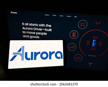 Stuttgart, Germany - 07-31-2021: Person Holding Cellphone With Logo Of Self-driving Vehicle Company Aurora Innovation Inc. On Screen In Front Of Webpage. Focus On Phone Display. Unmodified Photo.