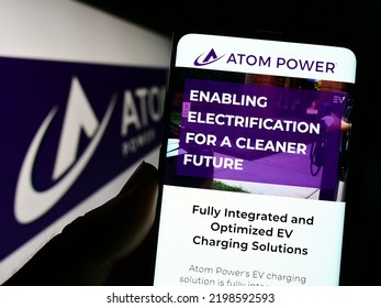 Stuttgart, Germany - 08-28-2022: Person Holding Cellphone With Website Of US Electric Charging Company Atom Power Inc. On Screen In Front Of Logo. Focus On Center Of Phone Display. Unmodified Photo.