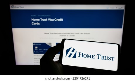 Stuttgart, Germany - 09-04-2022: Person Holding Mobile Phone With Logo Of Canadian Lender Home Trust Company On Screen In Front Of Business Web Page. Focus On Phone Display. Unmodified Photo.