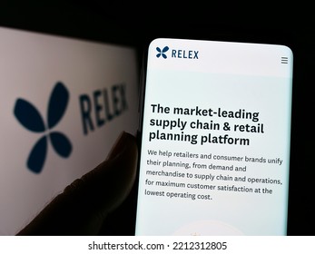 Stuttgart, Germany - 09-10-2022: Person Holding Cellphone With Webpage Of Finnish Software Company RELEX Solutions On Screen In Front Of Logo. Focus On Center Of Phone Display. Unmodified Photo.