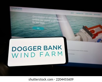 Stuttgart, Germany - 09-11-2022: Person Holding Cellphone With Logo Of Offshore Energy Generator Dogger Bank Wind Farm On Screen In Front Of Webpage. Focus On Phone Display. Unmodified Photo.