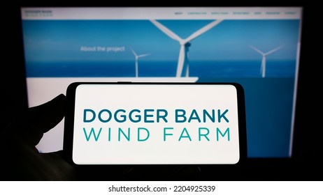 Stuttgart, Germany - 09-11-2022: Person Holding Smartphone With Logo Of Offshore Energy Generator Dogger Bank Wind Farm On Screen In Front Of Website. Focus On Phone Display. Unmodified Photo.