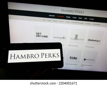 Stuttgart, Germany - 09-13-2022: Person Holding Mobile Phone With Logo Of British Investment Company Hambro Perks Limited On Screen In Front Of Web Page. Focus On Phone Display. Unmodified Photo.