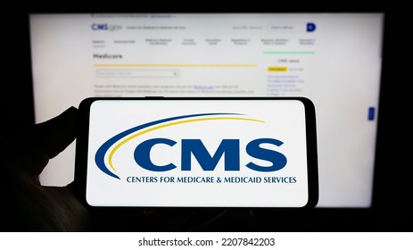 Stuttgart, Germany - 09-22-2022: Person Holding Mobile Phone With Logo Of Centers For Medicare And Medicaid Services (CMS) On Screen In Front Of Web Page. Focus On Phone Display. Unmodified Photo.