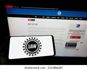 Stuttgart, Germany - 09-30-2022: Person Holding Smartphone With Logo Of US Trade Union United Auto Workers (UAW) On Screen In Front Of Website. Focus On Phone Display. Unmodified Photo.