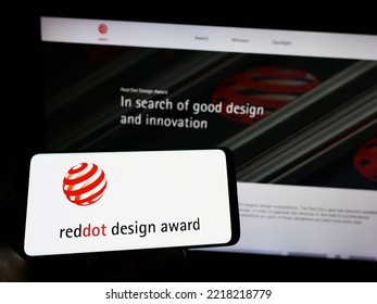 Stuttgart, Germany - 10-15-2022: Person Holding Cellphone With Logo Of German International Prize Red Dot Design Award On Screen In Front Of Webpage. Focus On Phone Display. Unmodified Photo.