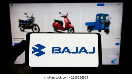 Stuttgart, Germany - 10-15-2022: Person Holding Mobile Phone With Logo Of Indian Automotive Company Bajaj Auto Limited On Screen In Front Of Web Page. Focus On Phone Display. Unmodified Photo.