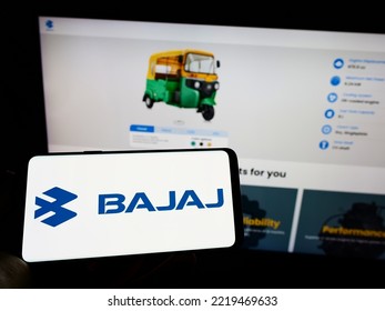 Stuttgart, Germany - 10-15-2022: Person Holding Cellphone With Logo Of Indian Automotive Company Bajaj Auto Limited On Screen In Front Of Business Webpage. Focus On Phone Display. Unmodified Photo.