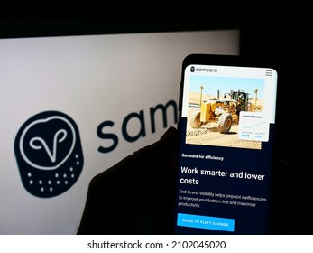Stuttgart, Germany - 12-11-2021: Person holding cellphone with webpage of US cloud software company Samsara Inc. on screen in front of logo. Focus on center of phone display. Unmodified photo.