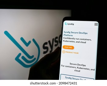 Stuttgart, Germany - 12-19-2021: Person Holding Cellphone With Webpage Of US Cloud Security Company Sysdig Inc. On Screen In Front Of Logo. Focus On Center Of Phone Display. Unmodified Photo.