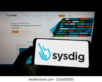 Stuttgart, Germany - 12-19-2021: Person Holding Cellphone With Logo Of US Cloud Security Company Sysdig Inc. On Screen In Front Of Business Webpage. Focus On Phone Display. Unmodified Photo.