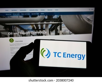 STUTTGART, GERMANY - Aug 16, 2021: Person Holding Smartphone With Logo Of Canadian Company TC Energy Corporation On Screen In Front Of Website  Focus On Phone Display 