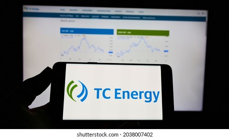 STUTTGART, GERMANY - Aug 16, 2021: Person Holding Mobile Phone With Logo Of Canadian Company TC Energy Corporation On Screen In Front Of Web Page  Focus On Phone Display 