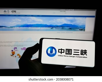 STUTTGART, GERMANY - Aug 16, 2021: Person holding cellphone with logo of power company China Three Gorges Corporation (CTG) on screen in front of webpage  Focus on phone display 