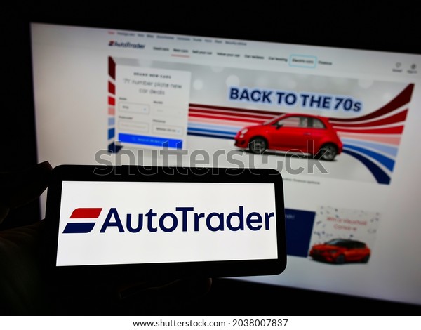 STUTTGART, GERMANY - Aug 16,\
2021: Person holding mobile phone with logo of marketplace\
Autotrader com Inc  on screen in front of web page  Focus on phone\
display 