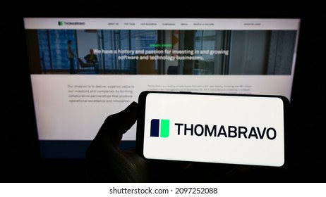 STUTTGART, GERMANY - Dec 13, 2021: Person Holding Mobile Phone With Logo Of American Private Equity Company Thoma Bravo L P  On Screen In Front Of Web Page  Focus On Phone Display 