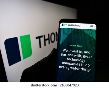 STUTTGART, GERMANY - Dec 13, 2021: Person Holding Cellphone With Webpage Of US Private Equity Company Thoma Bravo L P  On Screen In Front Of Logo  Focus On Center Of Phone Display 