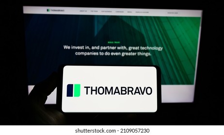 STUTTGART, GERMANY - Dec 13, 2021: Person Holding Smartphone With Logo Of US Private Equity Company Thoma Bravo L P  On Screen In Front Of Website  Focus On Phone Display 