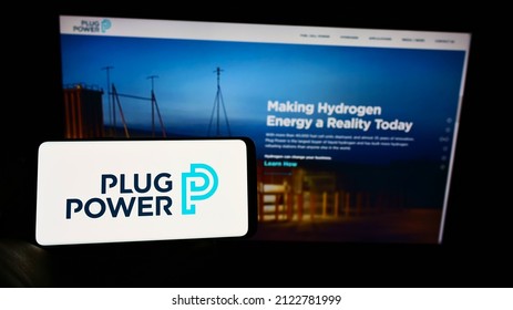 STUTTGART, GERMANY - Jan 23, 2022: Person Holding Cellphone With Logo Of American Hydrogen Fuel Cell Company Plug Power Inc  On Screen In Front Of Web Page  Focus On Phone Display 