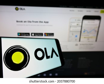 STUTTGART, GERMANY - Jul 12, 2021: Cellphone with logo of Indian ridesharing company Ola Cabs on screen in front of business website  Focus on left of phone display 