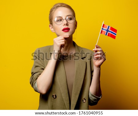 Style blonde woman in jacket with Norwegian flag on yellow background