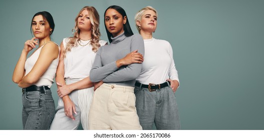 Style and confidence. Diverse group of empowered women standing together against a studio background. Self-confident female friends standing in a studio. - Shutterstock ID 2065170086