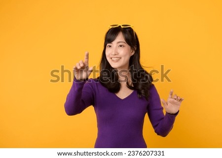 With style and sophistication, businesswoman in a purple shirt and sunglasses uses her virtual interface against a yellow background, symbolizing the digital age.