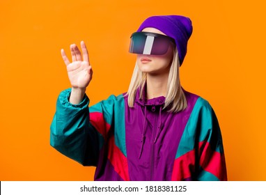 Style Woman In 90s Tracksuit With VR Glasses On Orange Background