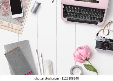 styled feminine desk background with various writing supplies, vintage camera and pink peony - top view, copyspace for your text