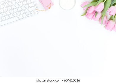 Styled flatlay with pink tulips on white background
