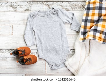 Styled Long Sleeve Grey Baby Onesie Mockup with boots and blanket