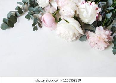 Styled stock photo. Decorative still life floral composition. Wedding or birthday bouquet of pink and white peony flowers and eucalyptus branches. White table background. Flat lay, top view. - Shutterstock ID 1155359239