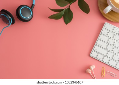 Stylierte Stockfotografie rosafarbener Schreibtischtisch mit leerem Notebook, Tastatur, Macaroon, Zubehör und Kaffeetasse. Draufsicht mit Kopienraum. Flat lay.