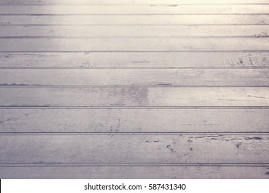 Stylised Shot Of Worn, White Wooden Floorboards At An Angle In Soft Natural Light.