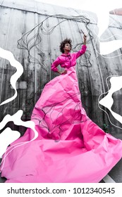 Stylish African American Model Holding Popsicle And Posing In Pink Paper For Fashion Shoot