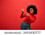 Stylish African American woman striking a pose in trendy red shirt and sunglasses.