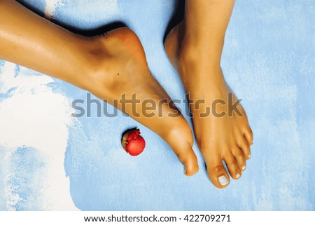 stylish african Female perfect shape feet, blue pedicure with pink flower, vacation on sea concept