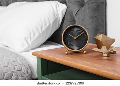 Stylish alarm clock and decor on nightstand in bedroom. Space for text
