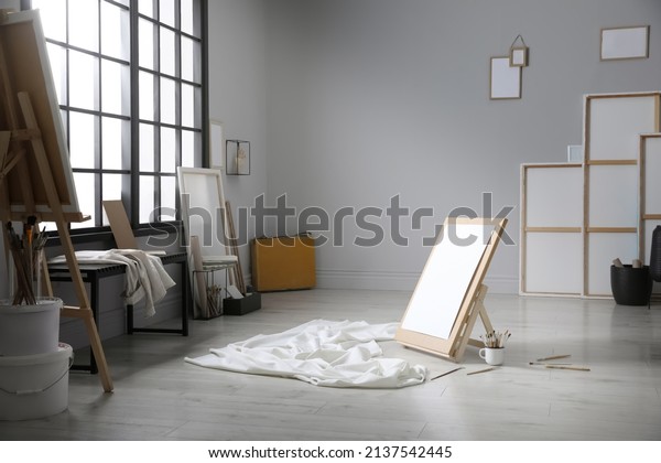 Stylish artist\'s studio interior with canvas,\
white fabric and\
brushes