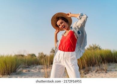 stylish attractive slim smiling woman on beach in summer style fashion trend outfit happy having fun wearing white pants red top blue shirt boho style chic and straw hat - Shutterstock ID 2172916951