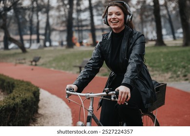 A stylish and attractive young businesswoman wearing headphones while riding a bicycle in an urban park setting, exuding confidence and joy. - Powered by Shutterstock