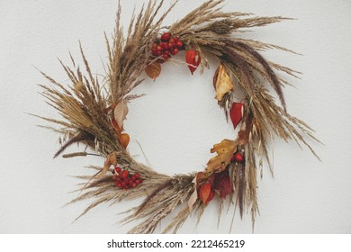 Stylish Autumn Wreath Hanging On White Wall Outdoor. Fall Decor And Arrangement Of Farmhouse. Thanksgiving. Rustic Autumn Wreath With Dried Grass, Berries, Herbs And Leaves